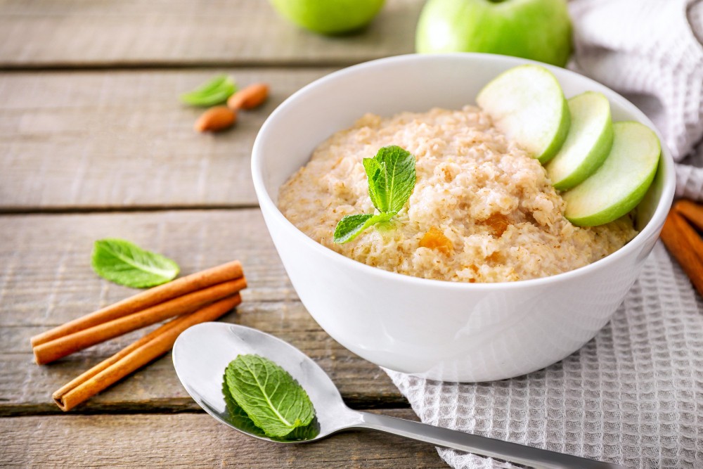 oatmeal-bowl-with-mint-leaves-apple-pieces-wooden-background