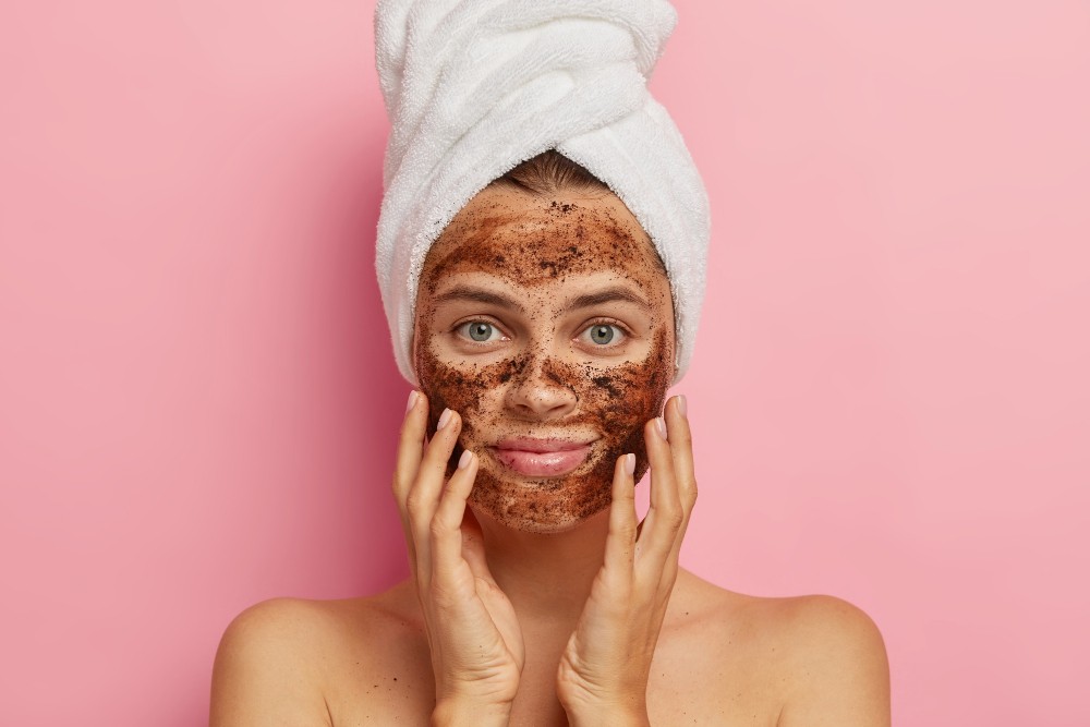 serious-young-lady-applies-coffee-scrub-face-does-peeling-skin-removes-pores-touches-cheeks-with-hands-has-naked-body(1)