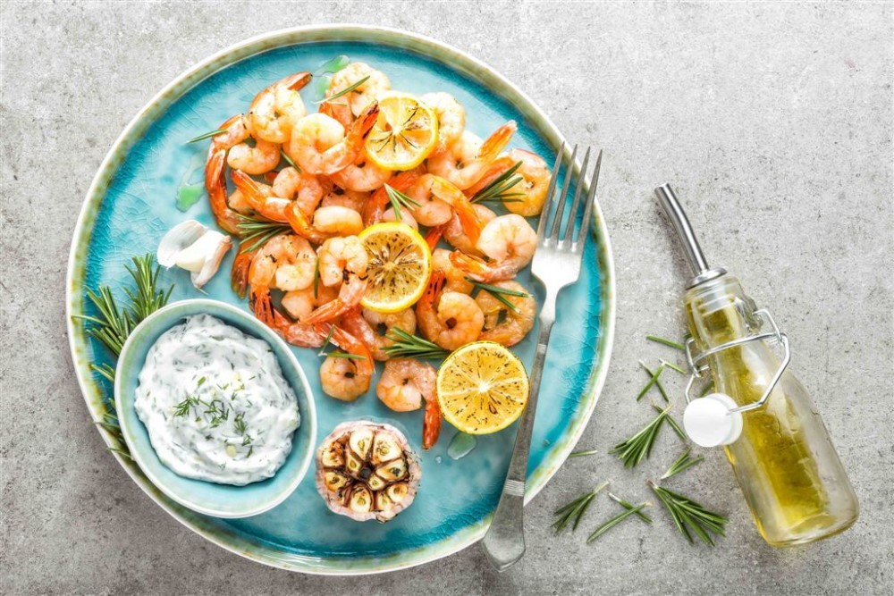 Grilled shrimps or prawns served with lemon, garlic and sauce. Seafood. Top view.