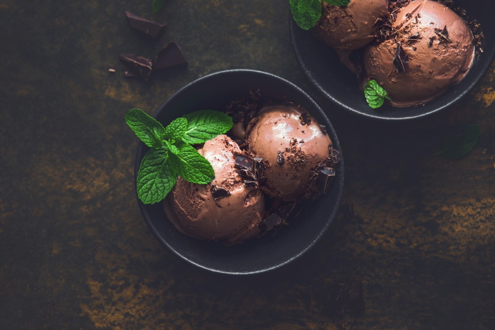 Dark chocolate ice cream served in black bowls, view from above